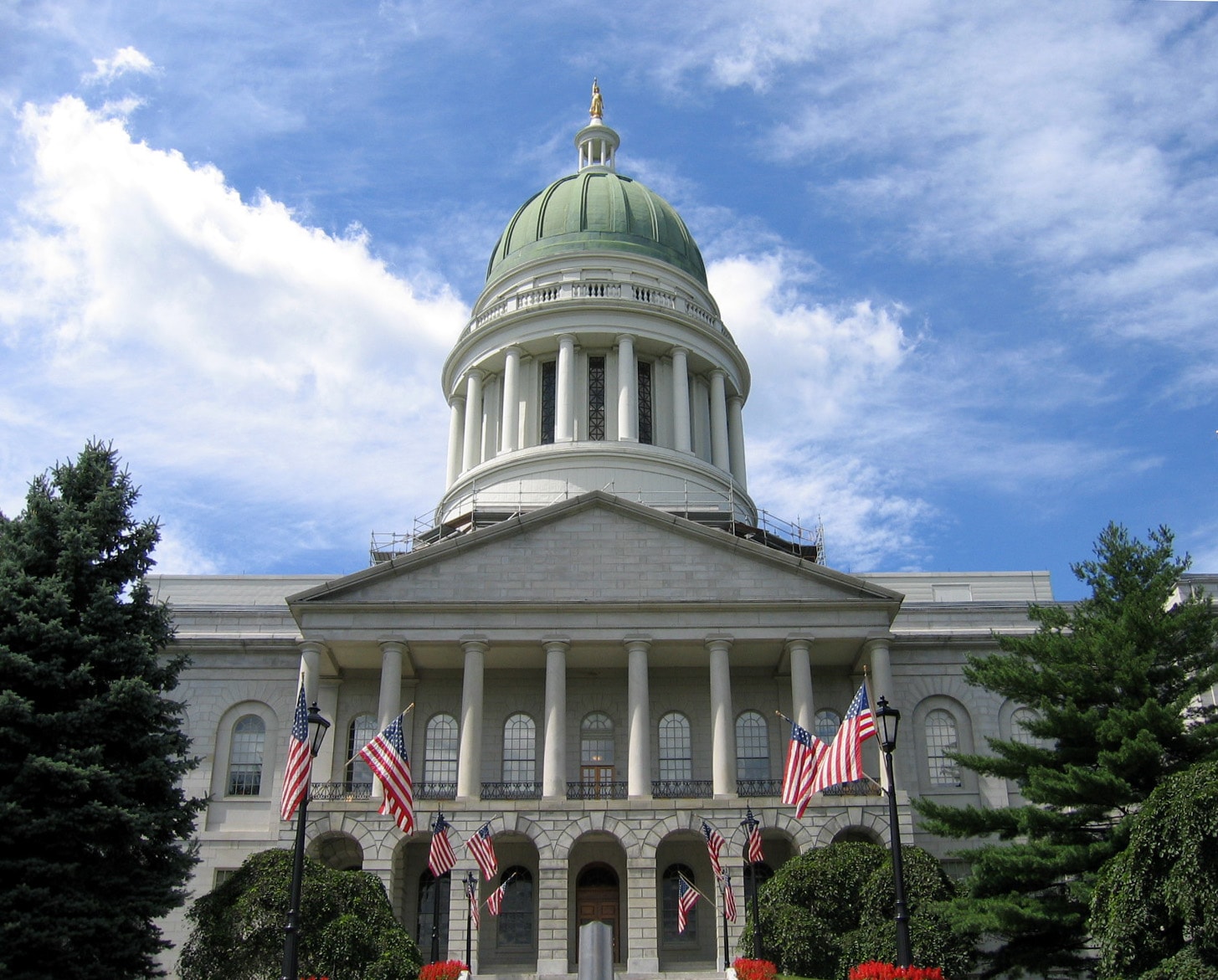 Maine State House in Augusta with green dome and American flags